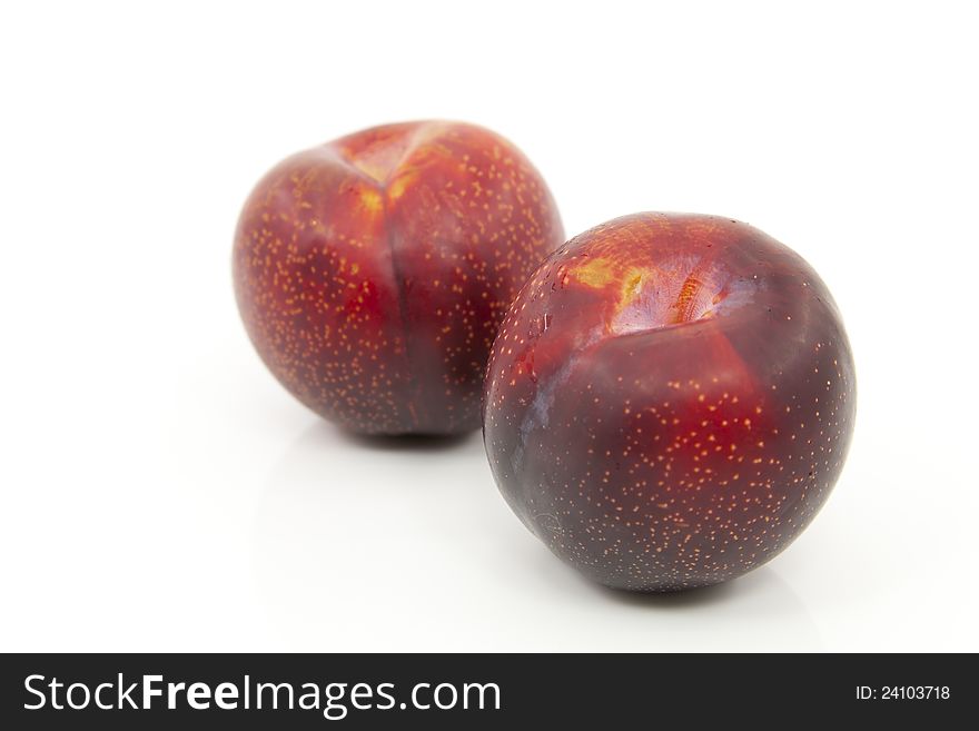 Delicious ripe red plums with white background