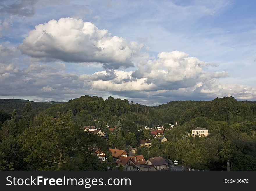 View of few houses in hilly area with cloudy summer sky. View of few houses in hilly area with cloudy summer sky