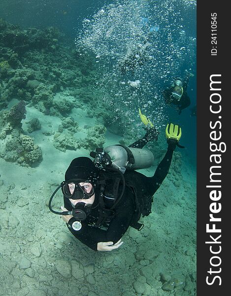 Silhouetted scuba diver swim on a coral reef under boat, in Red Sea. Silhouetted scuba diver swim on a coral reef under boat, in Red Sea