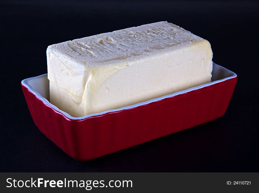 A one pound stick of butter in a butter serving dish. A one pound stick of butter in a butter serving dish.