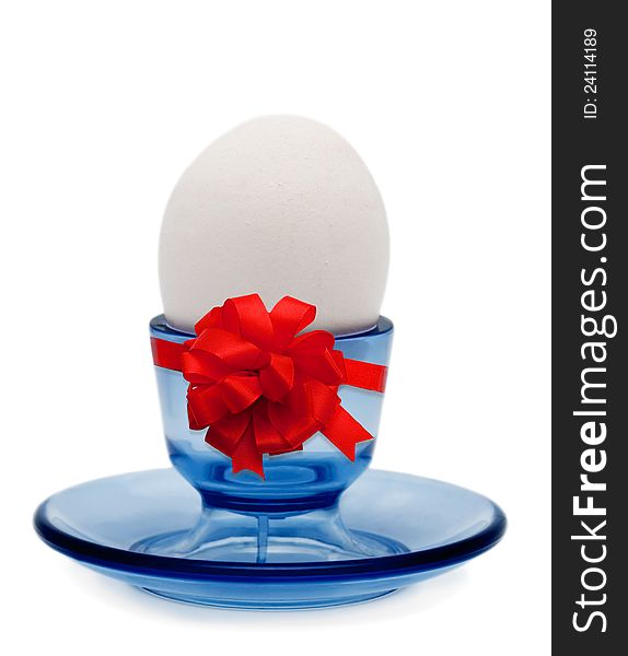 Egg in stand red holiday bow on white background