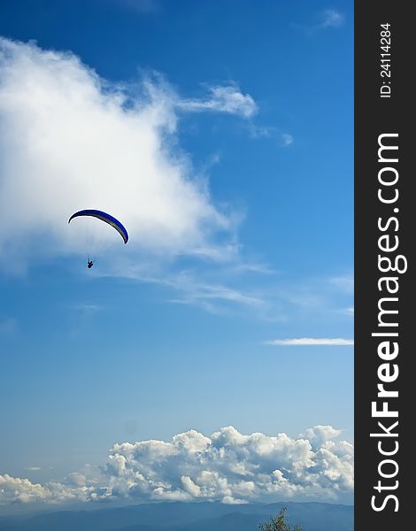 Paraglider on a sky with summer clouds background