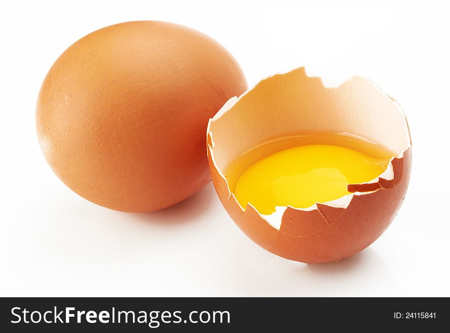 With brown eggs on a white background. One egg is broken