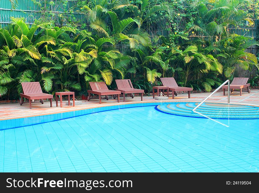 Wooden pool trestle beds by the resort poolside. Wooden pool trestle beds by the resort poolside