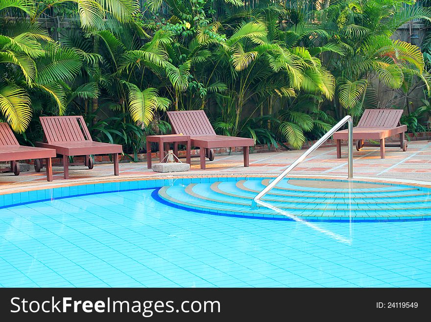 Wooden pool trestle beds by the resort poolside. Wooden pool trestle beds by the resort poolside