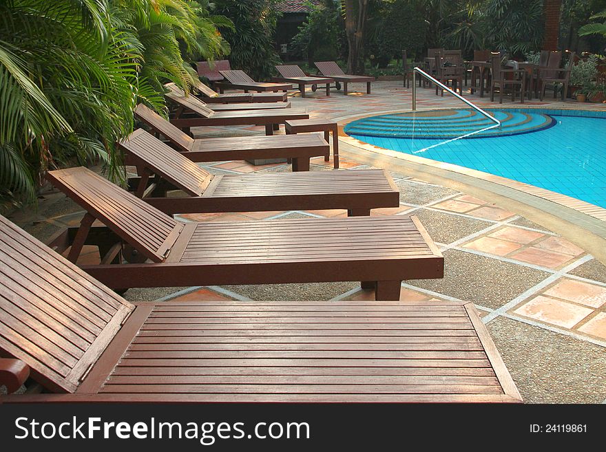 Wooden pool trestle beds by the resort poolside. Wooden pool trestle beds by the resort poolside
