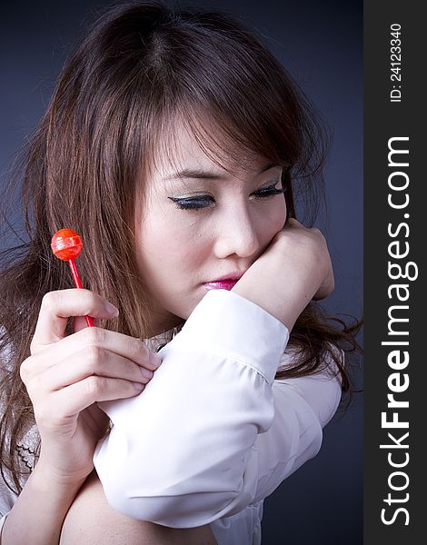 Female model pose cute action with red candy. Female model pose cute action with red candy.