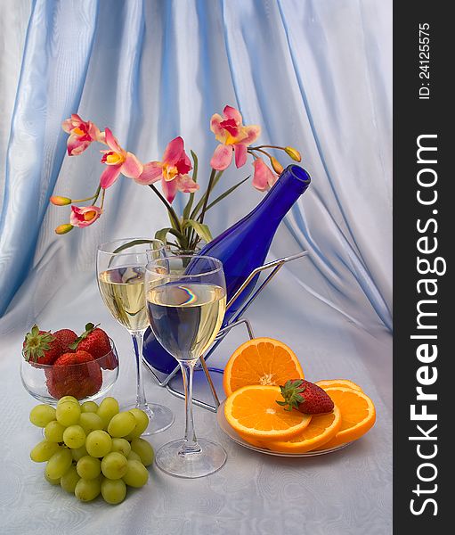 Two glasses of wine with fruits and orchid