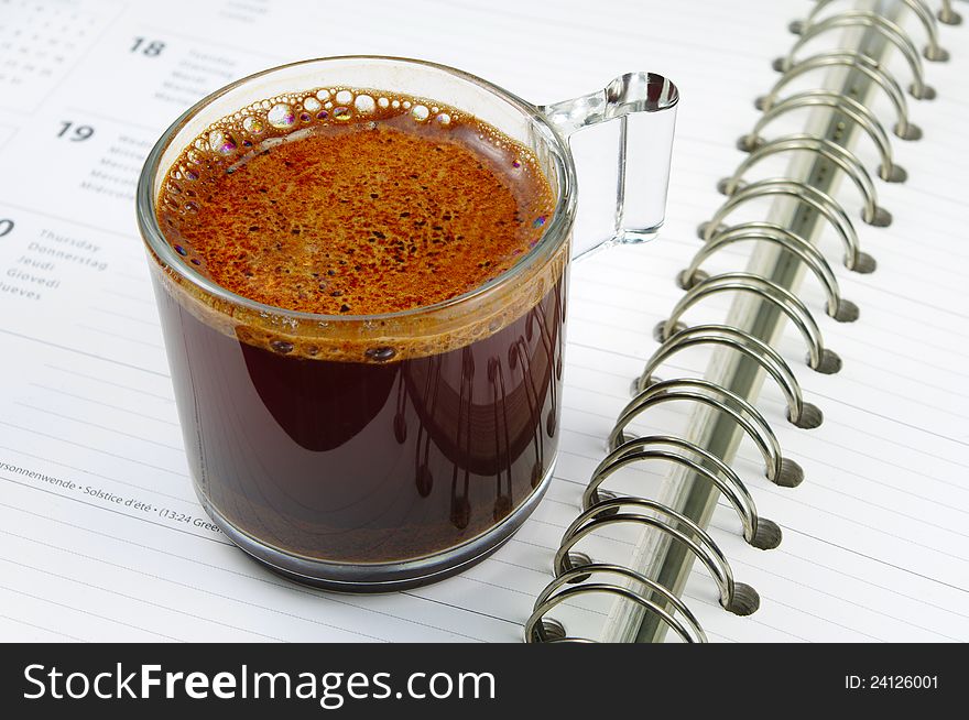 Cup of coffee and notepad with a spiral