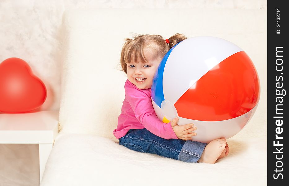 Portrait of a beautiful little girl holding a ball