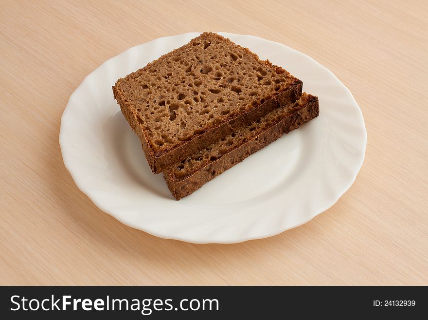 Two peaces of handmade black bread on plate
