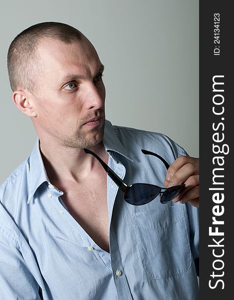 Serious young man in sunglasses in the studio