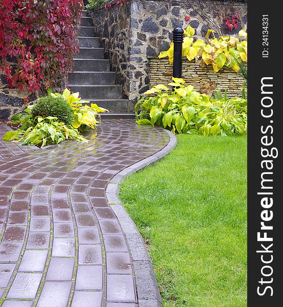 Garden stone path with grass growing up between the stones