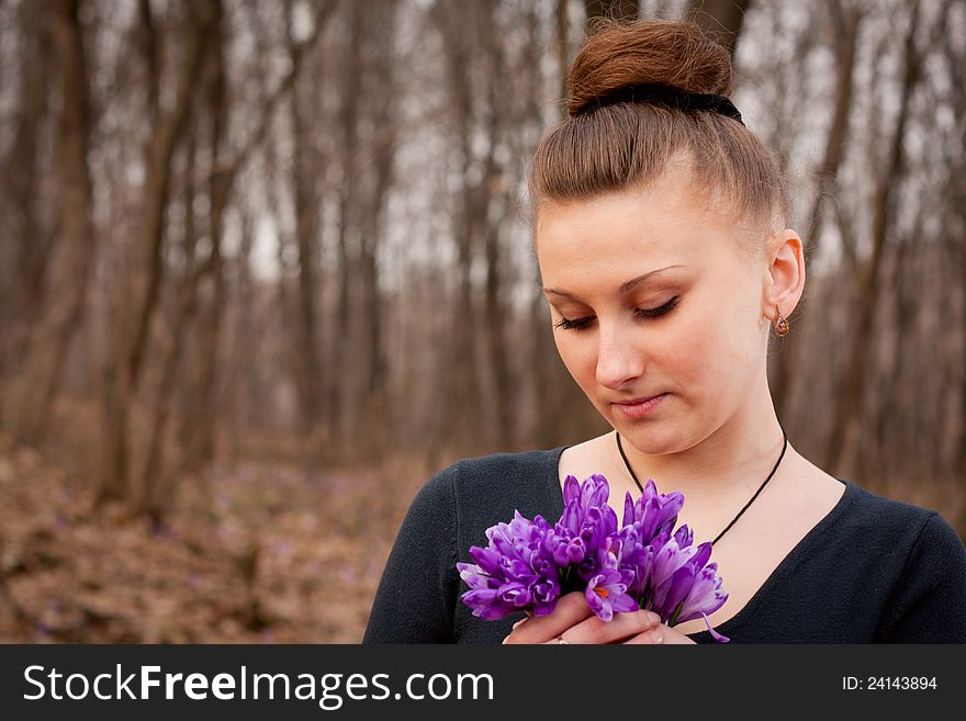 Beautiful girl with snowdrops in a forest