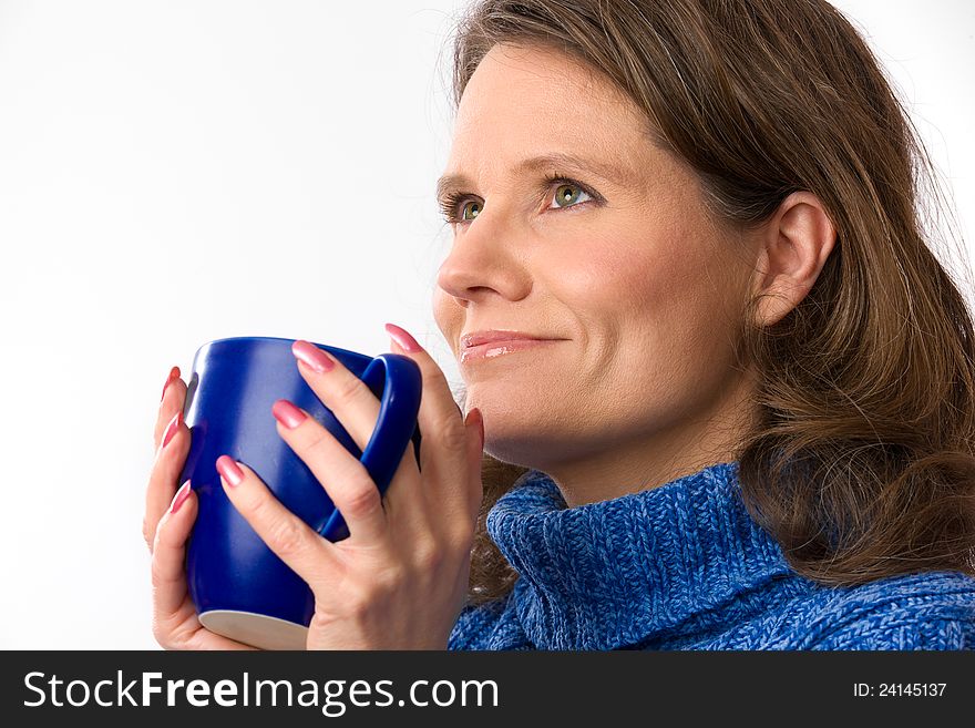 Closeup of a beautiful caucasian woman in her 40s holding a nice blue cup of warm beverage. Closeup of a beautiful caucasian woman in her 40s holding a nice blue cup of warm beverage