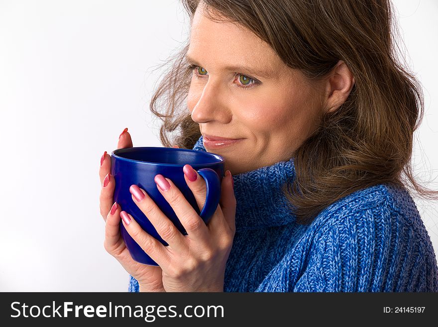 Closeup of a beautiful caucasian woman in her 40s holding a nice blue cup of warm beverage. Closeup of a beautiful caucasian woman in her 40s holding a nice blue cup of warm beverage
