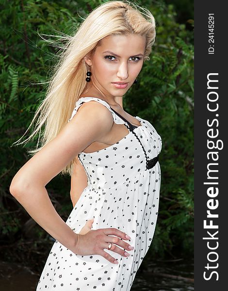 Young beautiful blonde female outdoors, dark background. Young beautiful blonde female outdoors, dark background