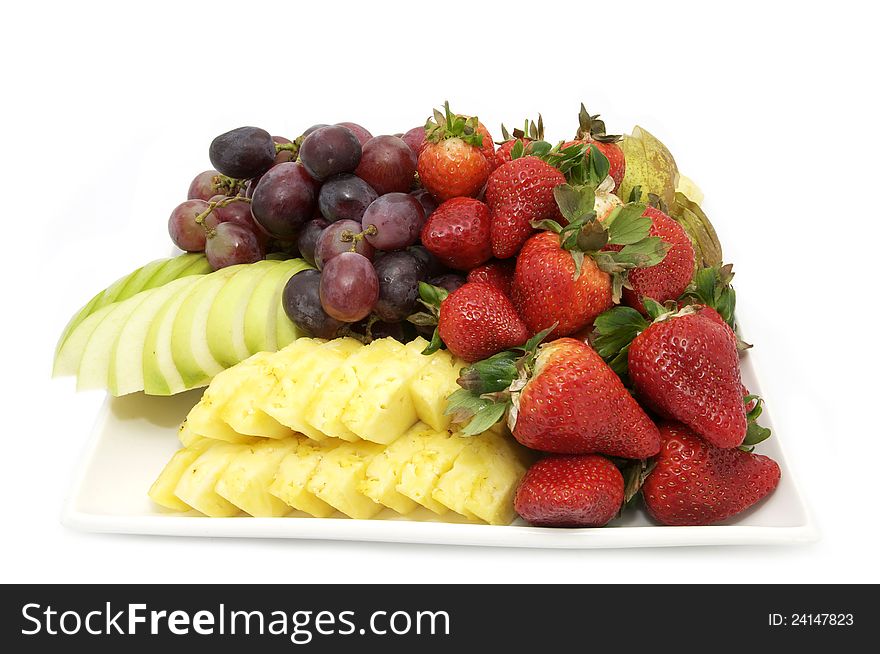 A plate of fresh fruit at a restaurant on a white background. A plate of fresh fruit at a restaurant on a white background