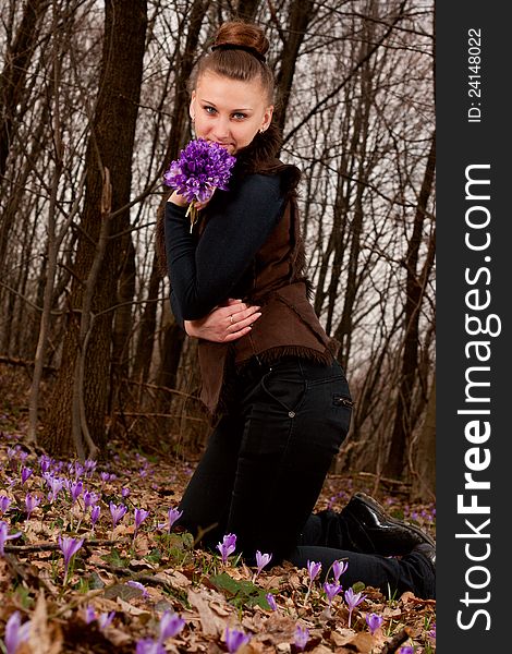 Beautiful girl with snowdrops in a forest