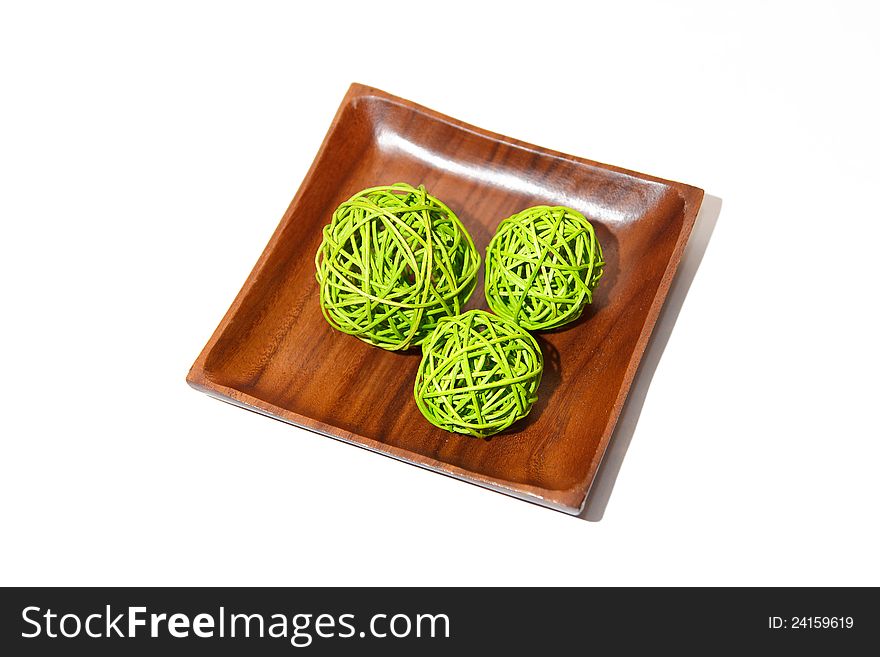 Wooden bowl with three green wicker balls. Interior decoration. Wooden bowl with three green wicker balls. Interior decoration.