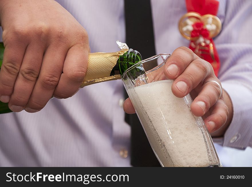 Hands pour wedding champagne in the glass. Hands pour wedding champagne in the glass