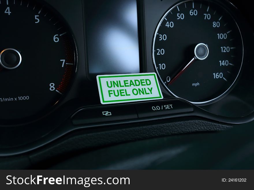 A sign on a vehicle dashboard indicating that only unleaded fuel can be used. A sign on a vehicle dashboard indicating that only unleaded fuel can be used