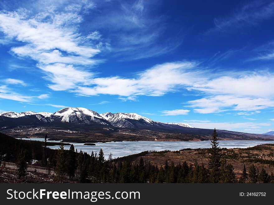 Frozen Rocky Mountain Lake with Blue Skies and wispy clouds. Frozen Rocky Mountain Lake with Blue Skies and wispy clouds