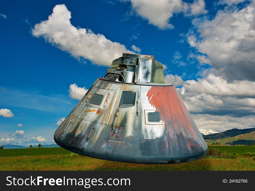 This space capsule lands on some prime farm land with blue sky. This space capsule lands on some prime farm land with blue sky