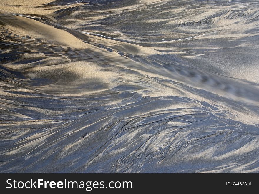 Beach sand with a small trickle of water flowing. Beach sand with a small trickle of water flowing