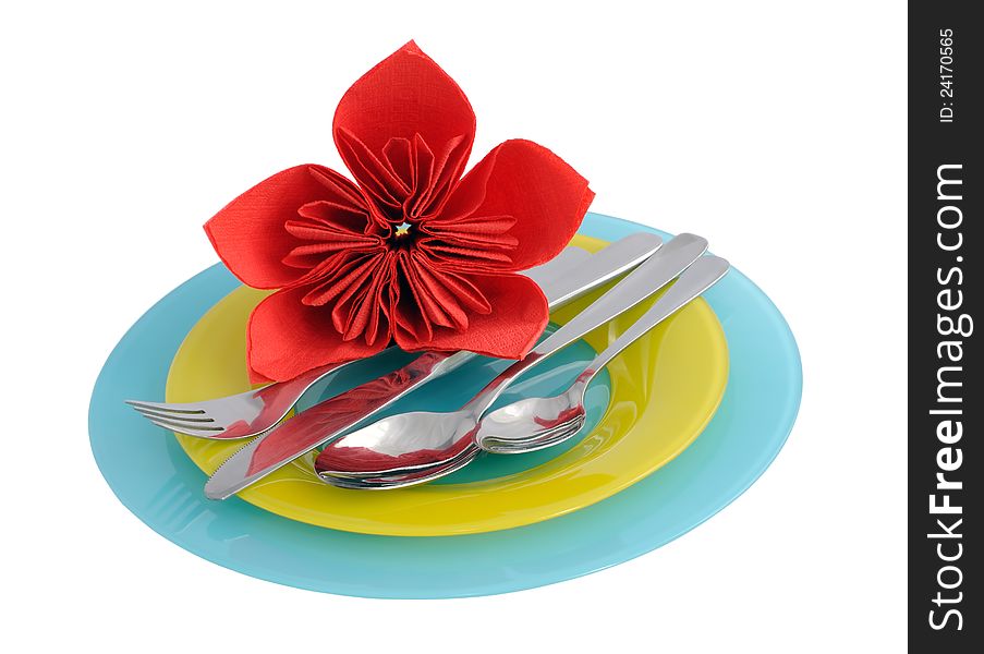 A set of cutlery on a plate with a flower from a tissue (isolated)