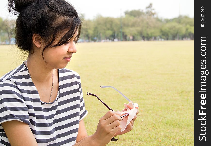 Girl cleaning her glasses