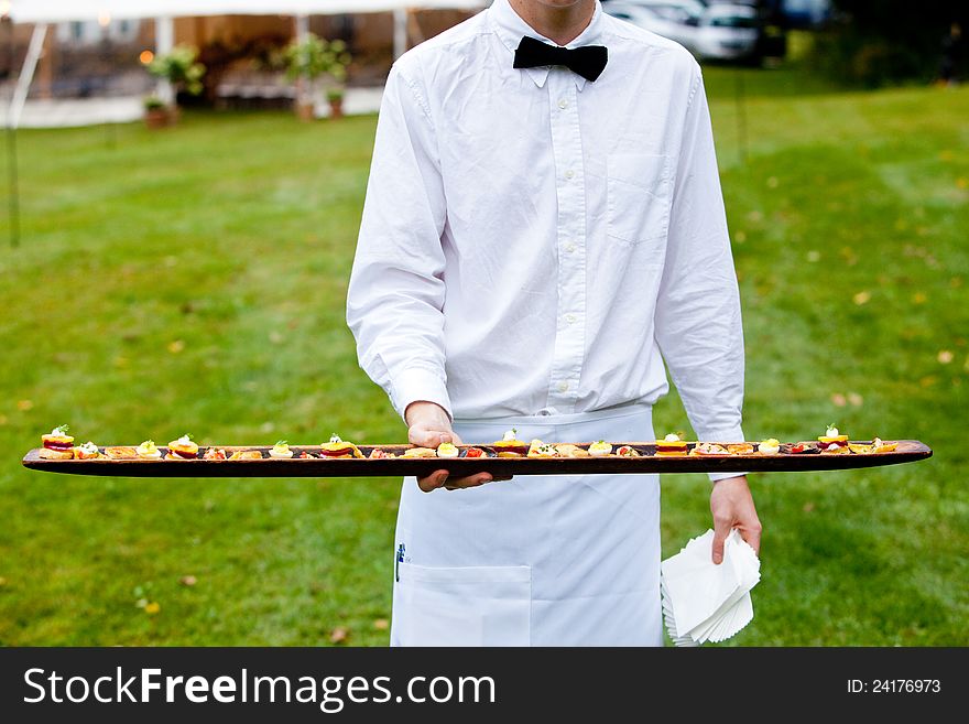 A waiter serving appetizers at a wedding or catered event. A waiter serving appetizers at a wedding or catered event