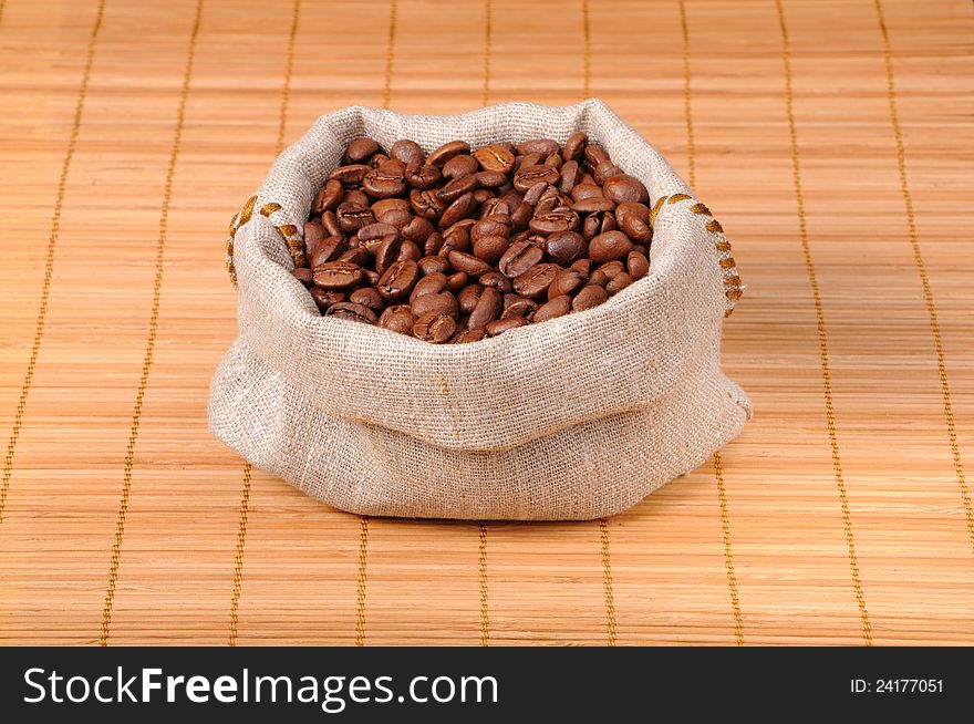 Coffee beans in a bag on a wooden napkin