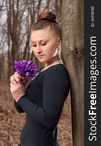 Beautiful girl with snowdrops in a forest