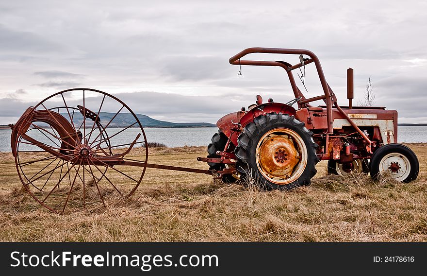 Old tractor with hay collectors in tow