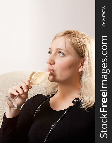 Young beautiful woman drinks wine from wine glass