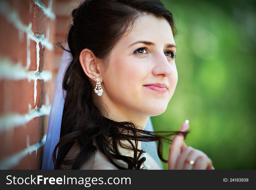 Happy bride in wedding walk neear red brick wall