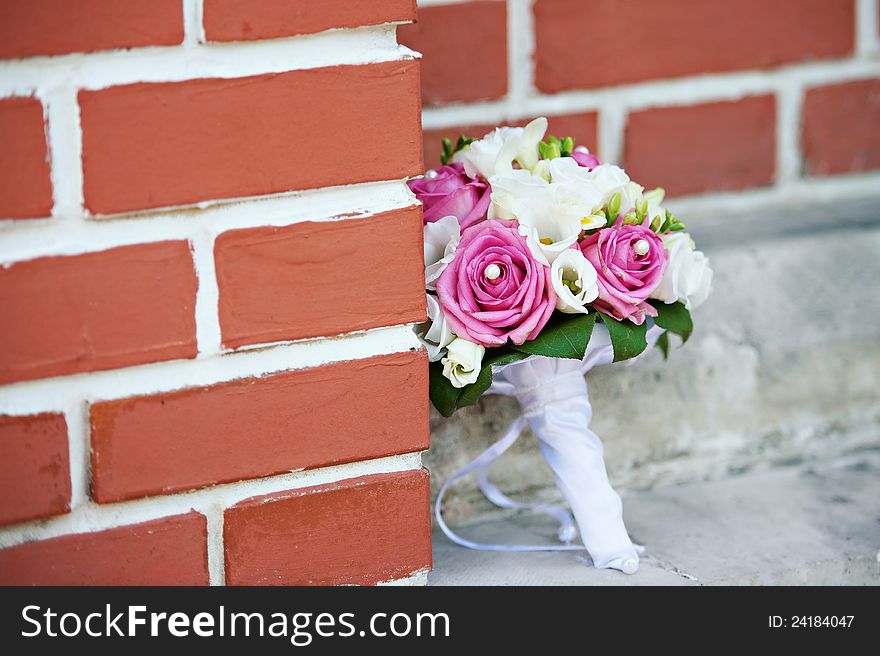 Wedding bouquet of roses about red brick wall