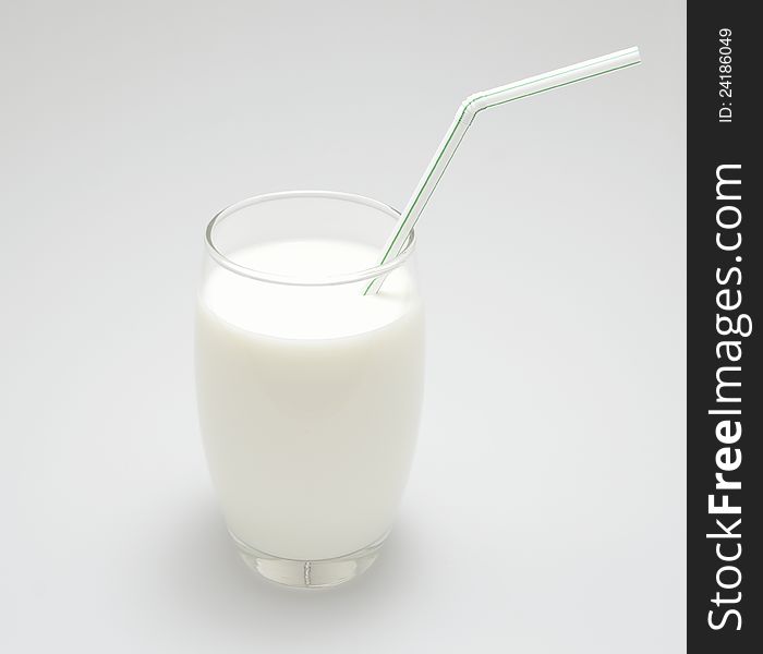 A glass of milk with a green straw