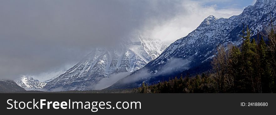 This image of the rugged snowy mountains with the storm clouds moving in was taken in Glacier National Park, MT. This image of the rugged snowy mountains with the storm clouds moving in was taken in Glacier National Park, MT.