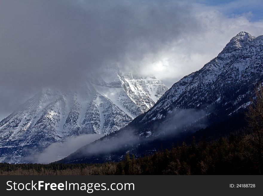This image of the rugged snowy mountains with the storm clouds moving in was taken in Glacier National Park, MT. This image of the rugged snowy mountains with the storm clouds moving in was taken in Glacier National Park, MT.