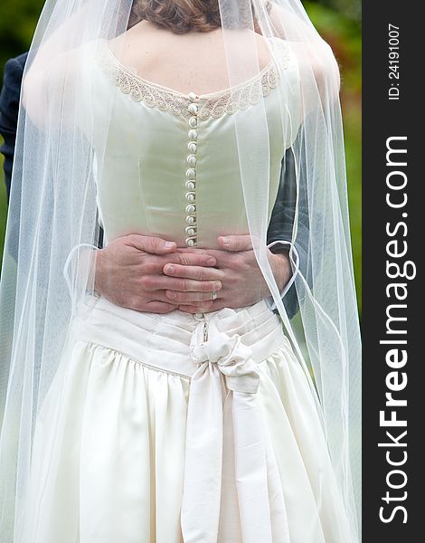 A groom is holding his bride, she is wearing a white dress. A groom is holding his bride, she is wearing a white dress