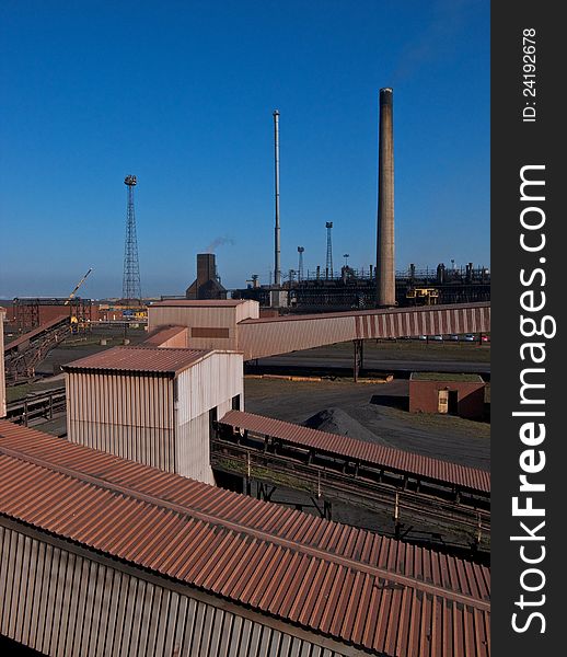 Industrial chimneys and conveyors in a coke manufacturing plant. Industrial chimneys and conveyors in a coke manufacturing plant.