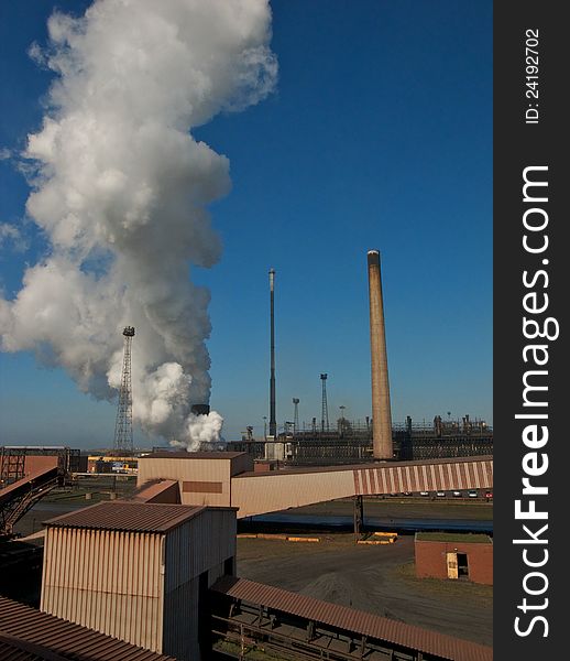 Industrial chimneys billowing steam into the blue sky. Industrial chimneys billowing steam into the blue sky
