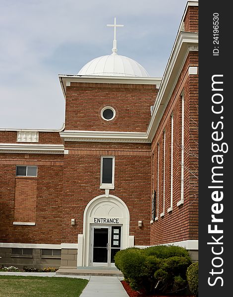 Image of a orange brick church building with a cross on top. Image of a orange brick church building with a cross on top