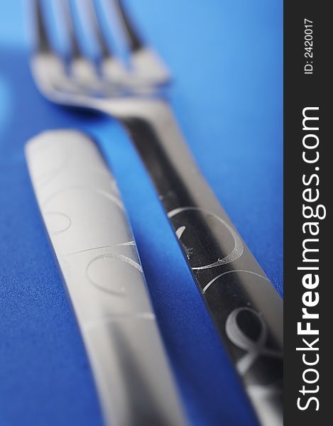 Two forks facing different dirrections on blue background