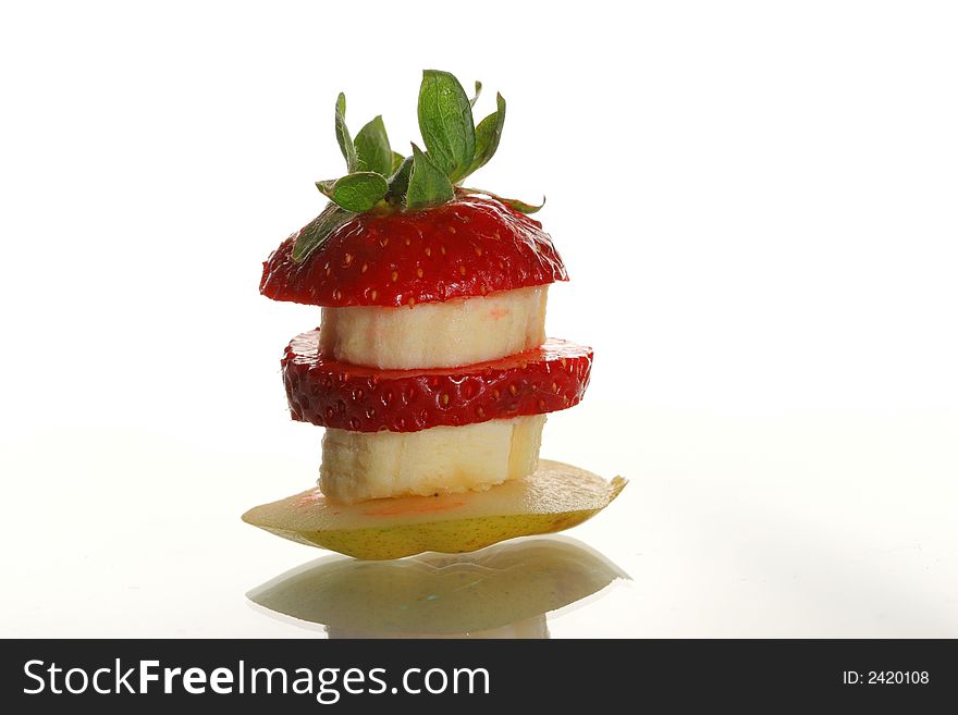 Slices of a strawberry, pear and banana on a white background