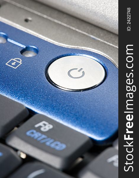 Close-up of Power-Button of a laptop with blue applications.