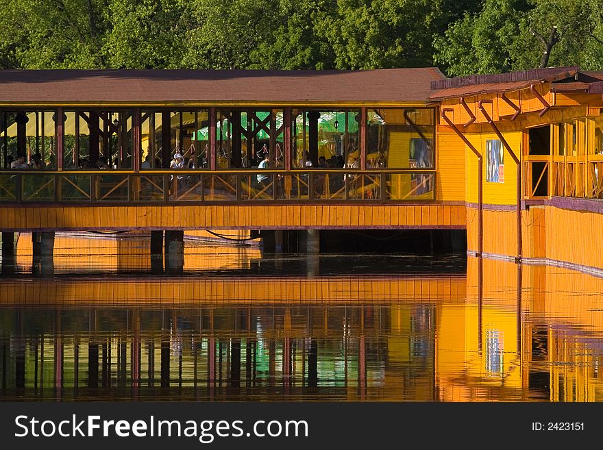 Orange reflection of a wood building on the lake