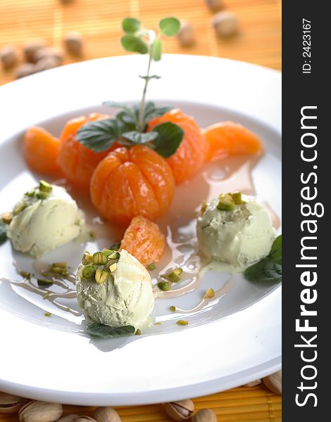 Hot tangerines with pistachio ice cream on the plate